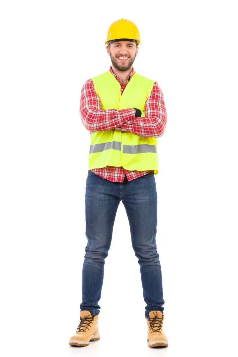 Smiling construction worker in yellow helmet and lime waistcoat posing with arms crossed. Full length studio shot isolated on white.